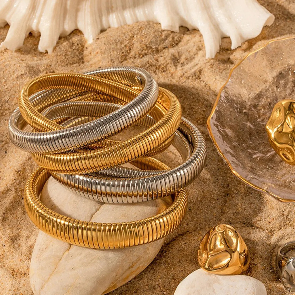 Women's vertical stripe ring titanium steel bracelet in gold and silver colours showing elastic construction.