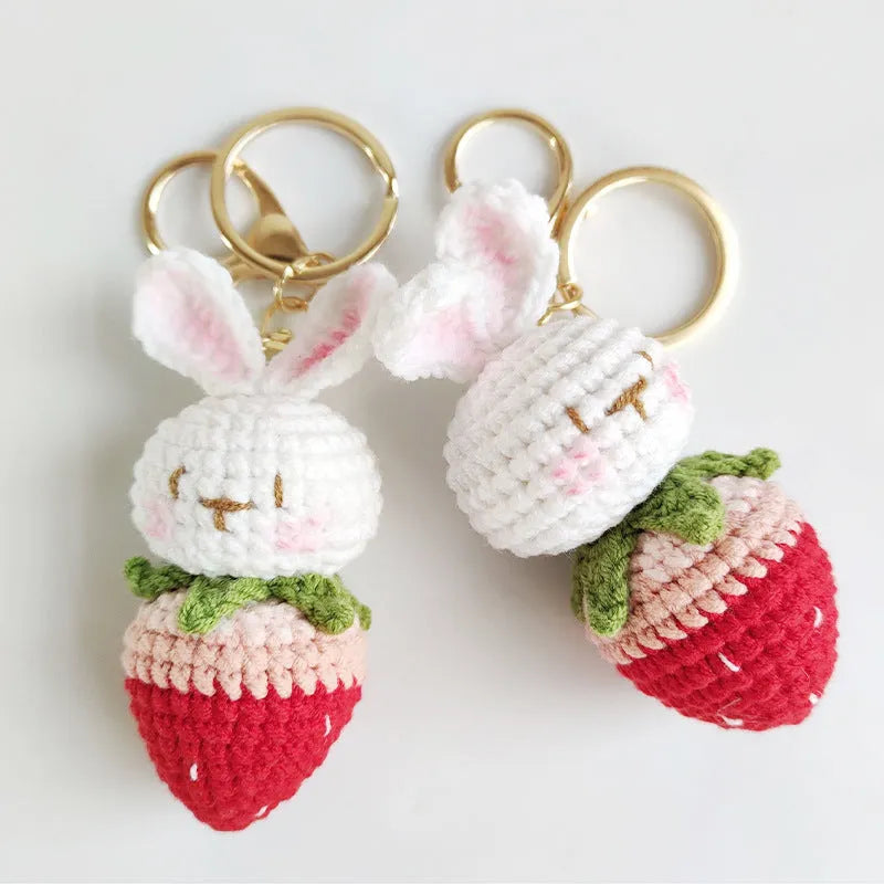 White hand-woven wire pendant with a rabbit and strawberry design on a key ring