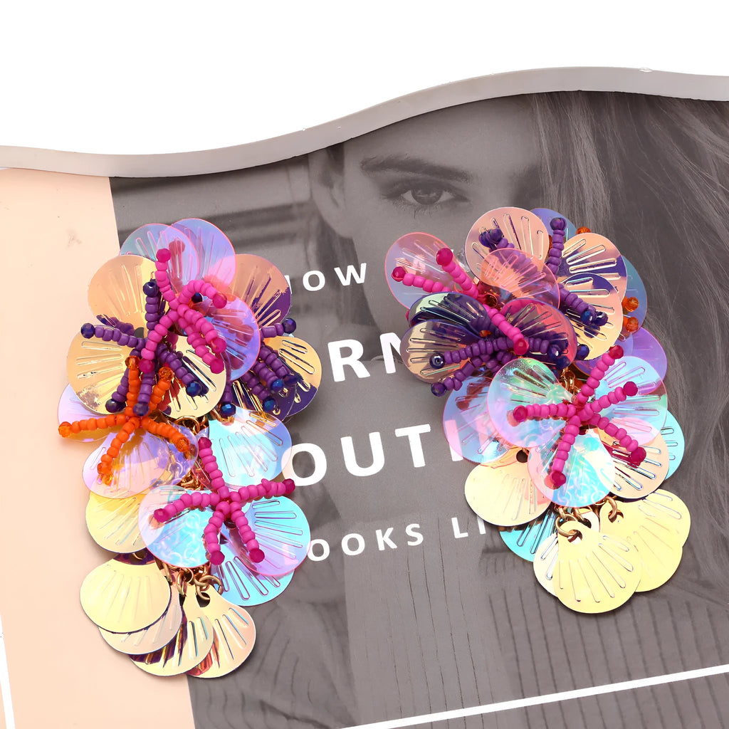Close-up of handmade colourful string bead flower and leaf earrings in exaggerated dopamine style.