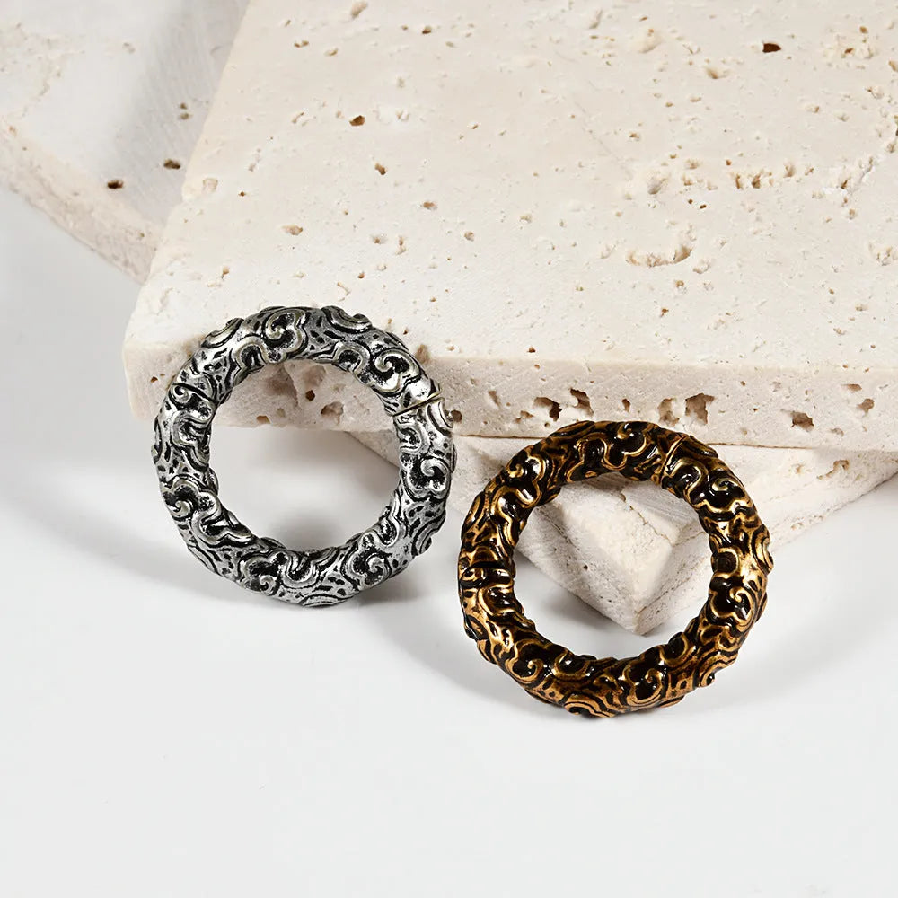 A pair of silver fashion earrings with a raised totem pattern, shown in one of 15 available electroplated colour finishes.