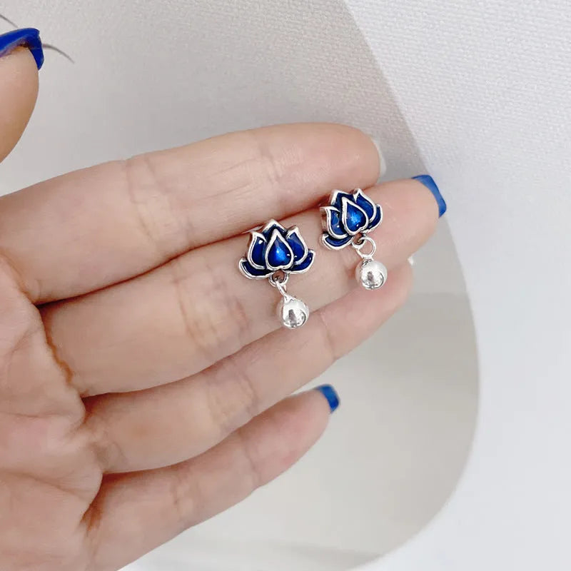 Blue alloy lotus flower stud earrings with a dangling seedpod tassel on silver posts.