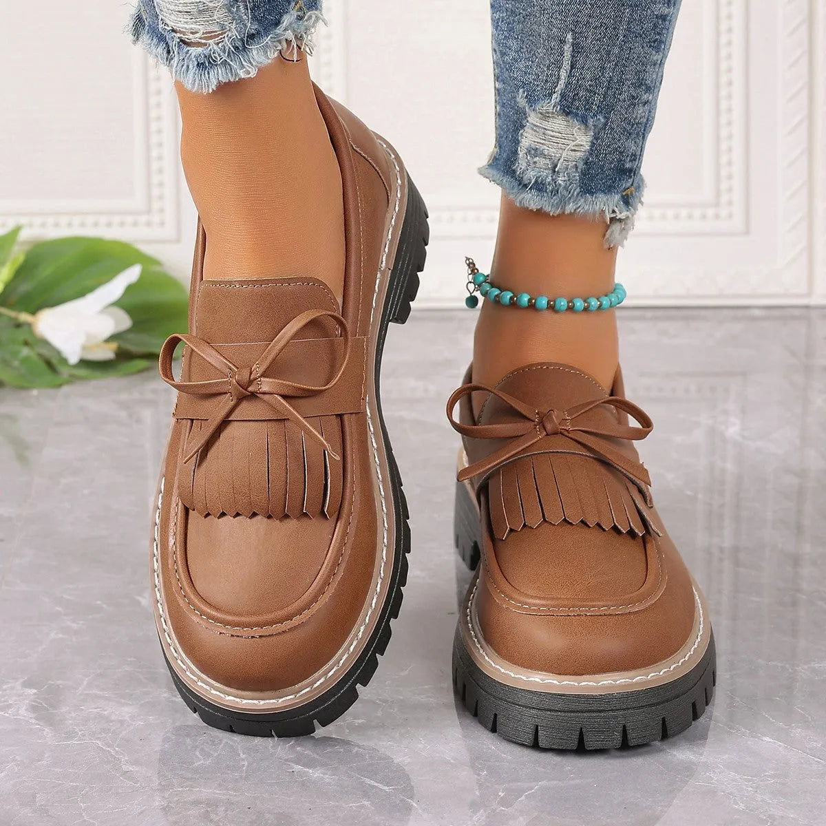 Plus size black loafers for women with a tassel bowknot and chunky low heel.