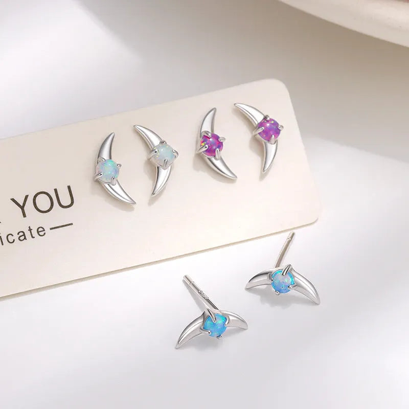 A pair of geometric-shaped sterling silver earrings with a gold-plated finish and a central blue zirconia stone.