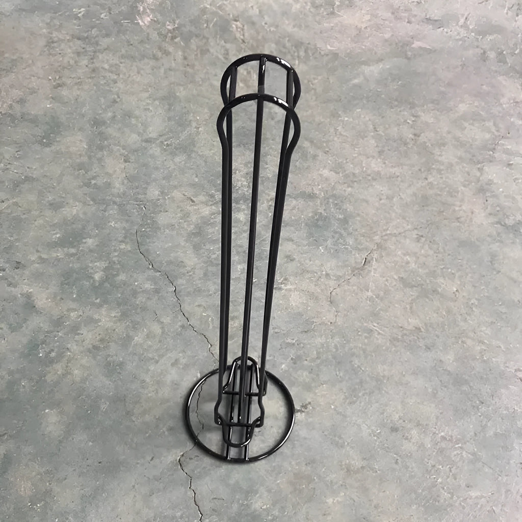 Black wrought iron coffee capsule storage rack holding pods on shelves