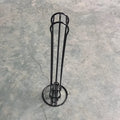 Black wrought iron coffee capsule storage rack holding pods on shelves
