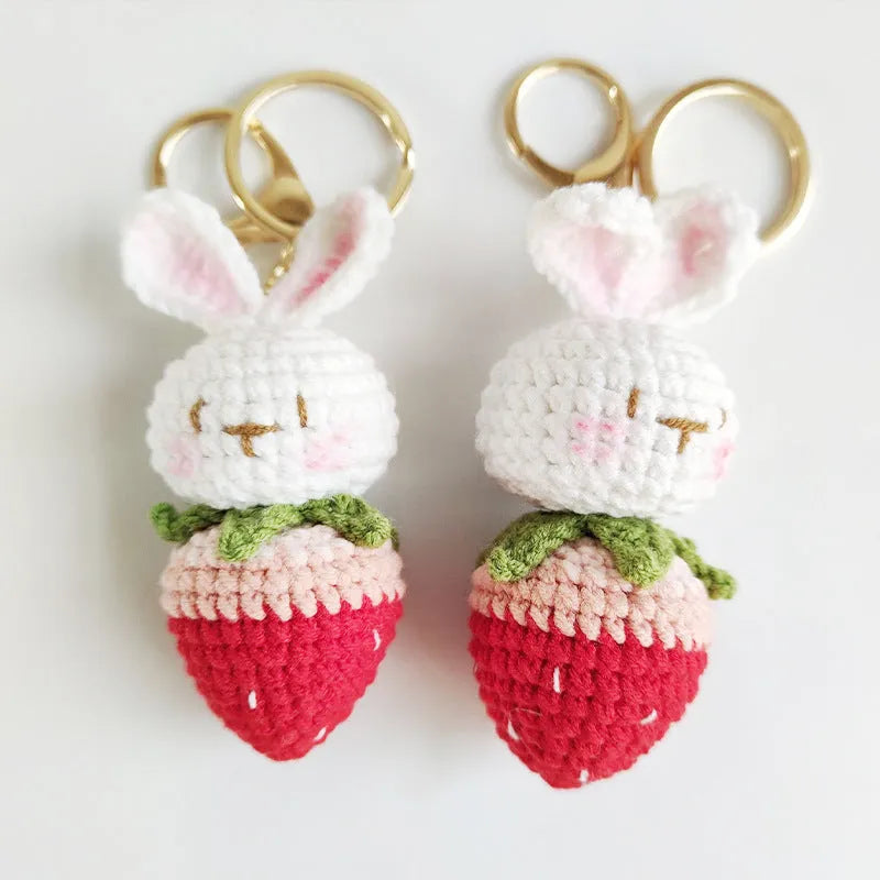 White hand-woven wire pendant with a rabbit and strawberry design on a key ring