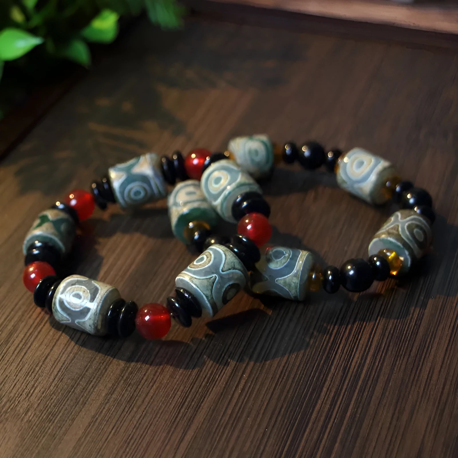 Distressed agate Tibetan bead bracelet with three-eye motifs and polished finish.