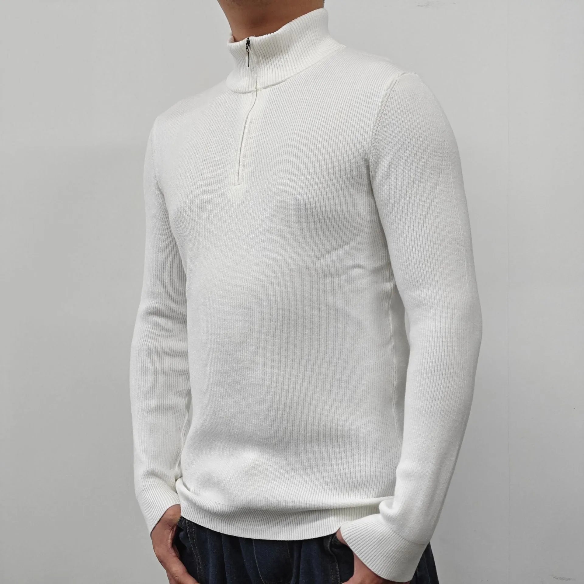 Man wearing a grey zip-up half-turtleneck sweater with long sleeves.