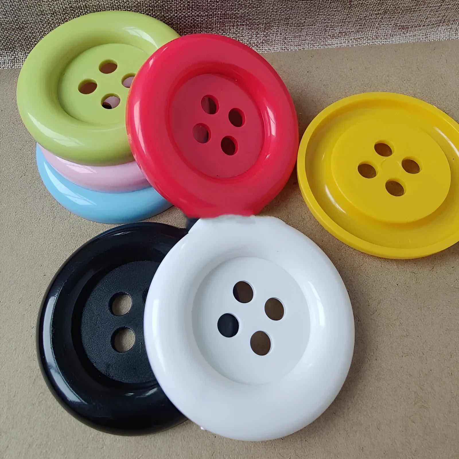 Plastic nylon oversize round sewing buttons in multiple colours showing four-hole design
