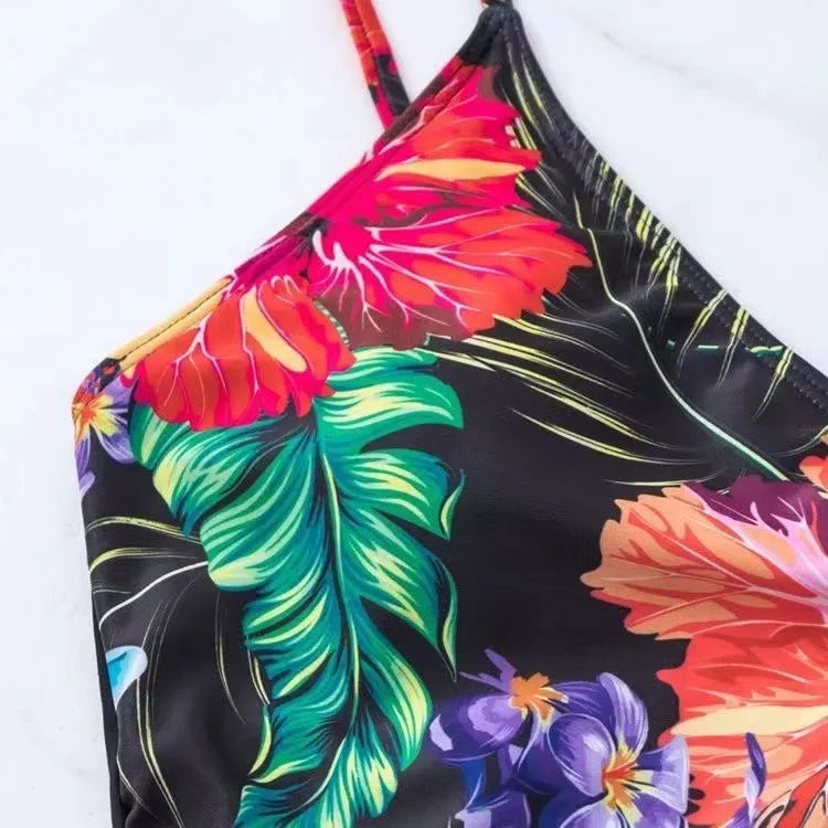 Black women's high waist briefs printed split bikini swimwear laid flat.