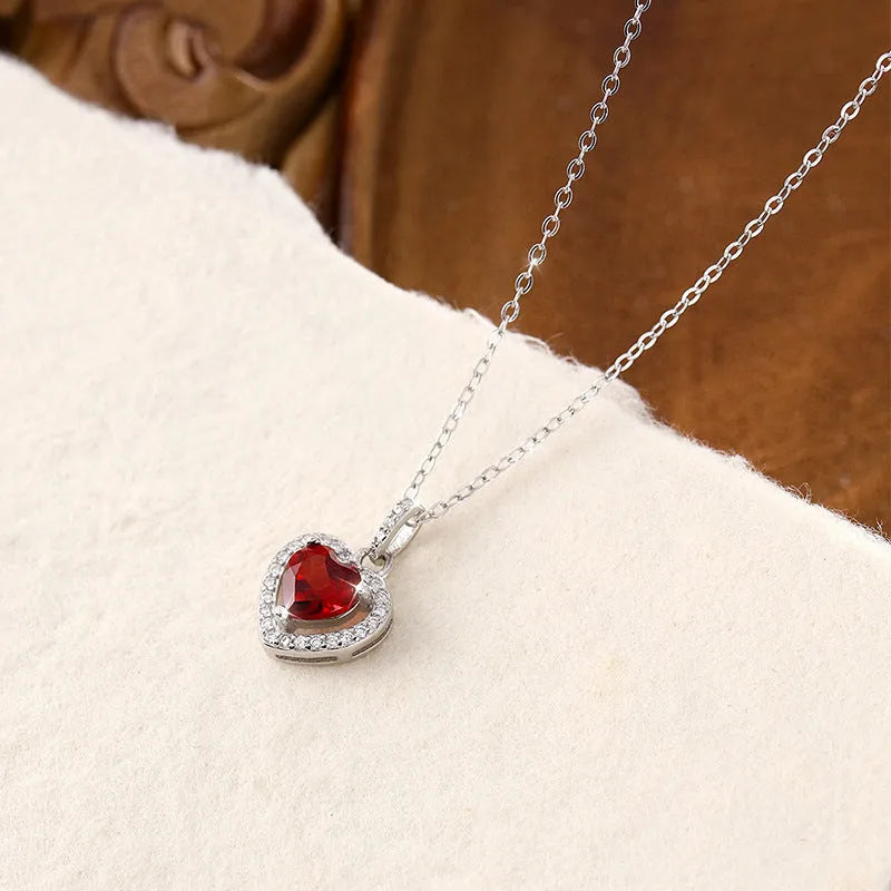 Women's sterling silver necklace with a heart-shaped amethyst pendant on an adjustable cross chain.