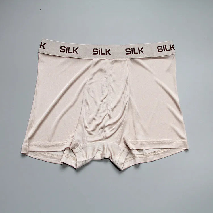 Men's loose fitting silk shorts in navy blue, shown on a mid-waist.
