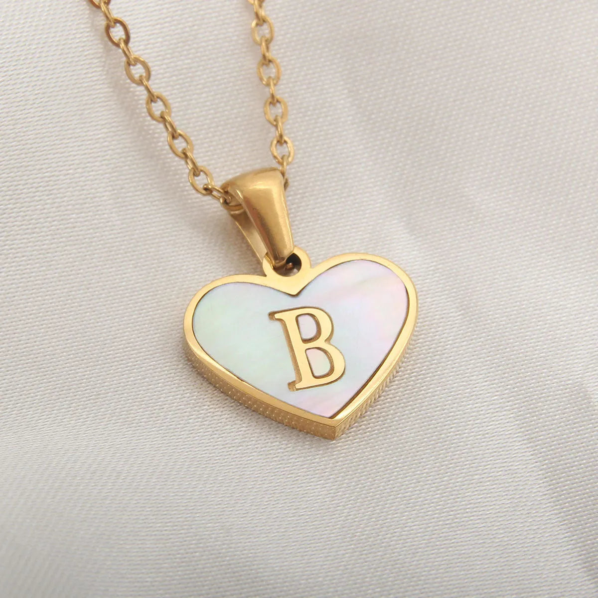 Gold plated initial necklace with white shell heart pendant and adjustable chain