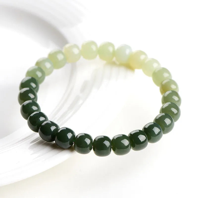 Natural Hetian jade bracelet showing a clear water gradient colour on polished beads.