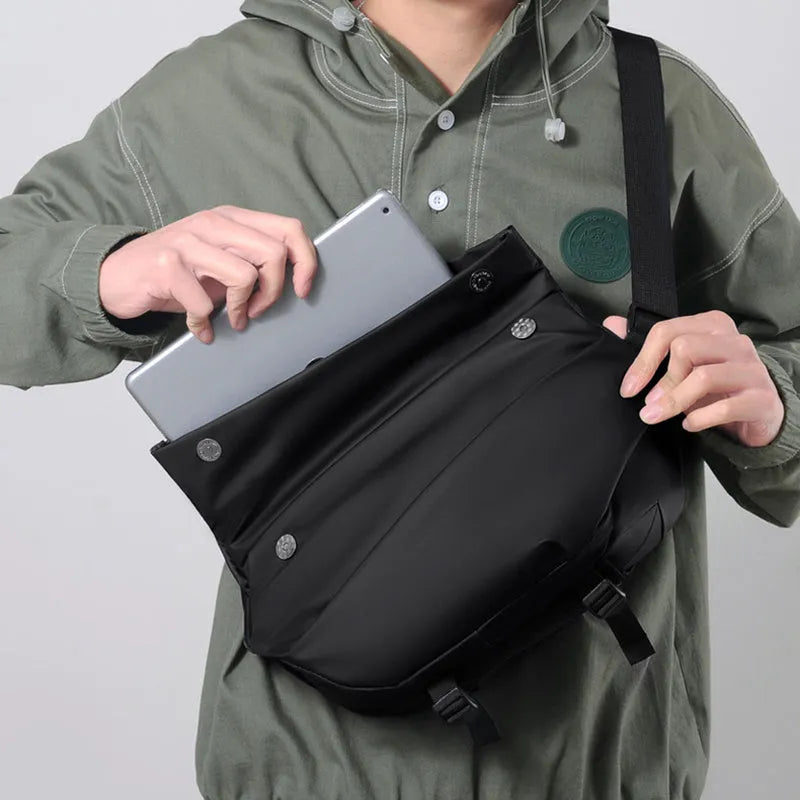 Grey horizontal square crossbody bag for men with a single shoulder strap and zipper.