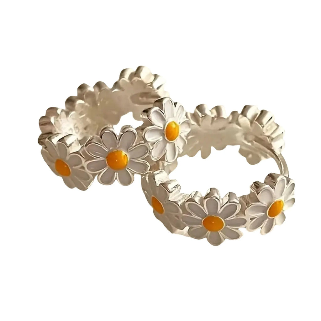 White electroplated daisy flower ring earrings with platinum gem settings on a copper base.