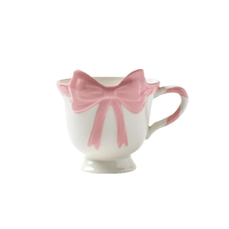 Ceramic mug with heart and bow design in white or black pink colours