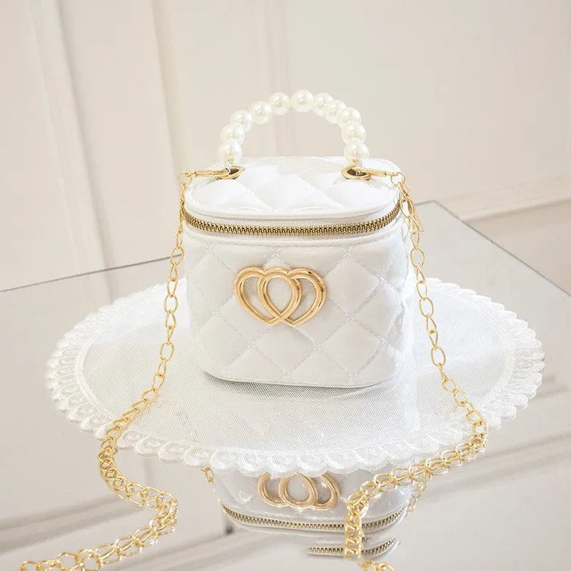 White PVC bucket shoulder bag with a heart-shaped pattern, showing its jelly-like material.