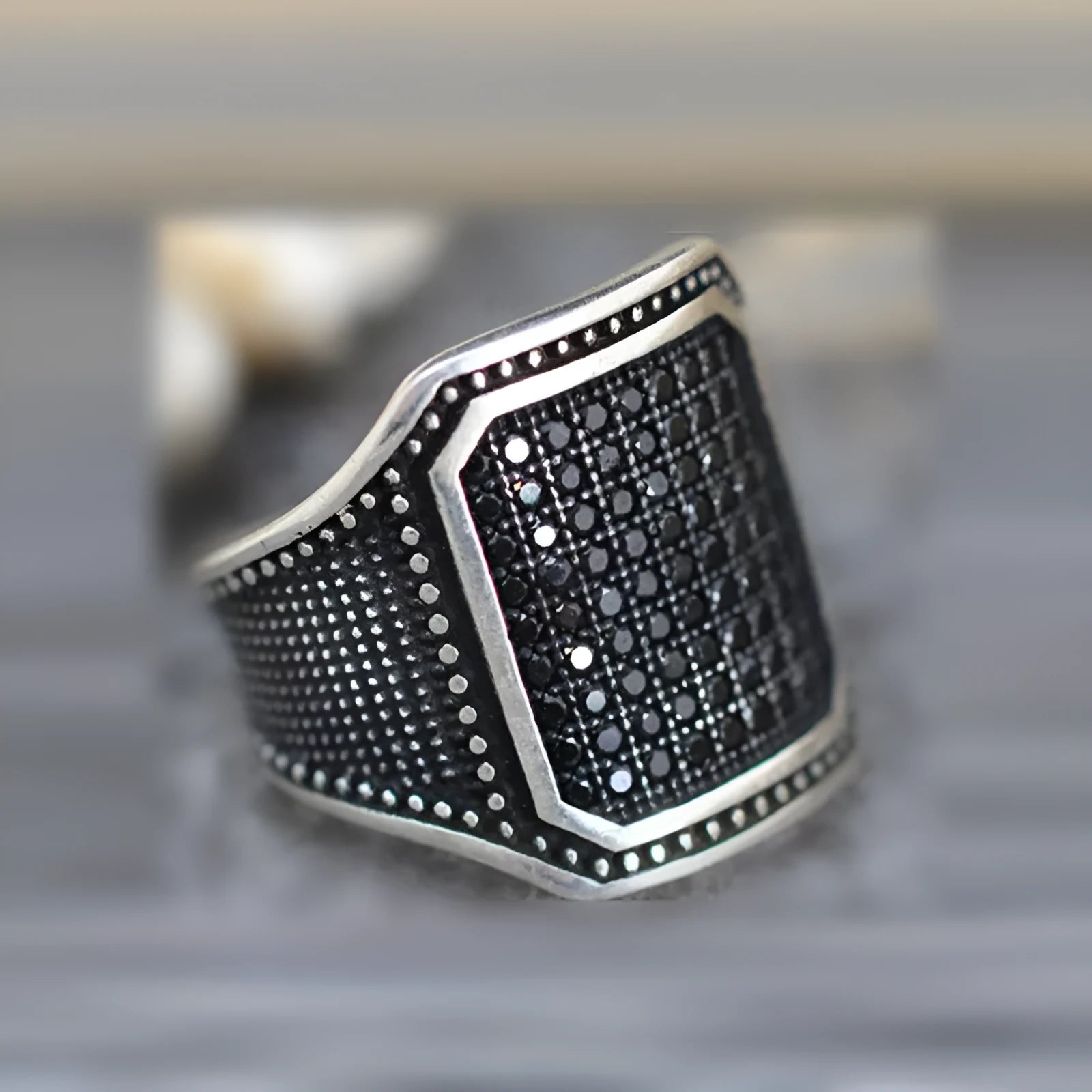 Black alloy ring with copper inlay and zircon accents on a finger, showing European and American styling.