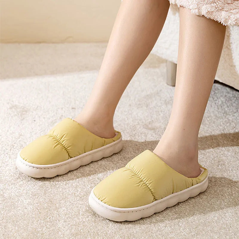 A pair of thick-soled plush slippers with artificial leather uppers and non-slip rubber soles in a choice of five colours.
