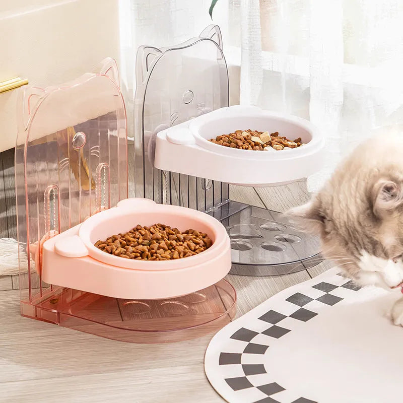 Grey adjustable height cat feeding bowl with cat ears and removable cage on a white background.