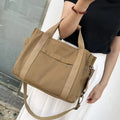 Large horizontal square canvas tote bag in army green with visible sewing lines and open zipper sides.