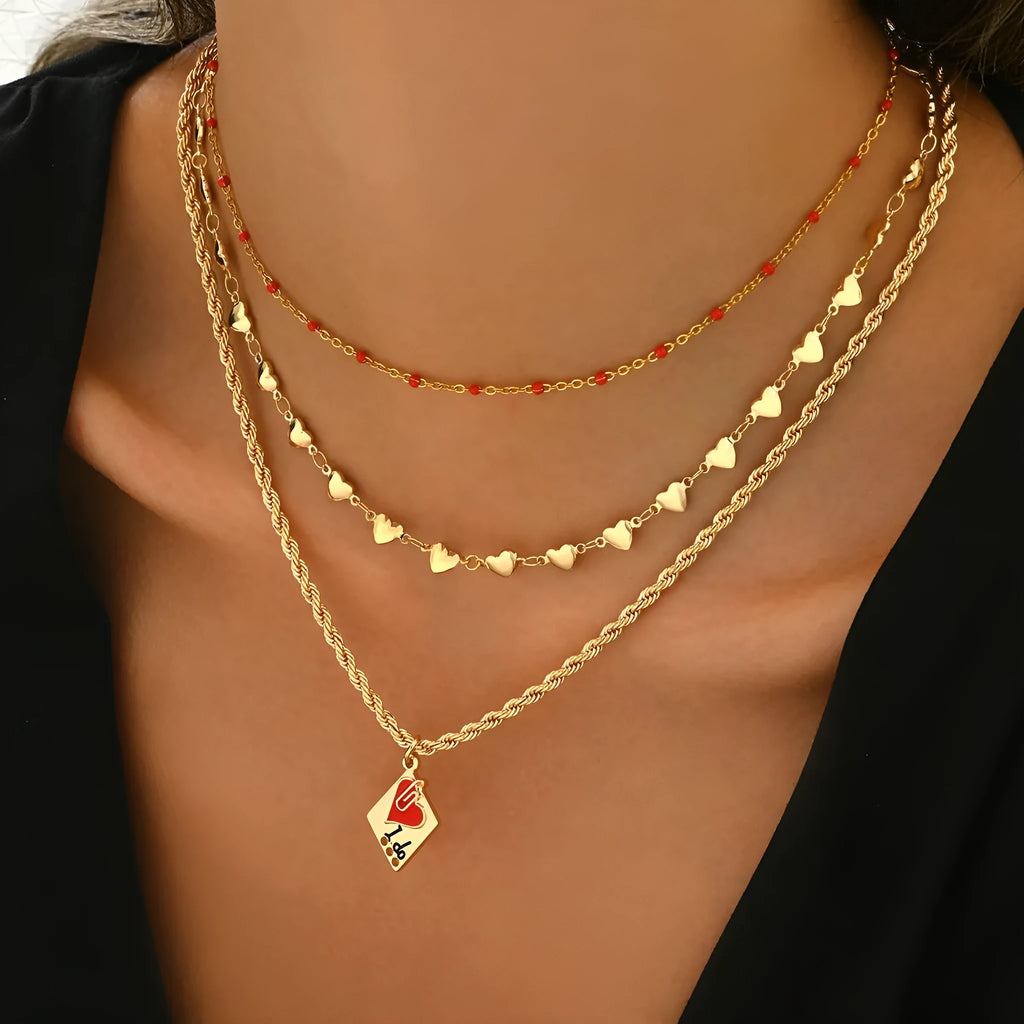 Close-up of a three-layer zinc alloy clavicle chain necklace with geometric shapes and a heart pendant.