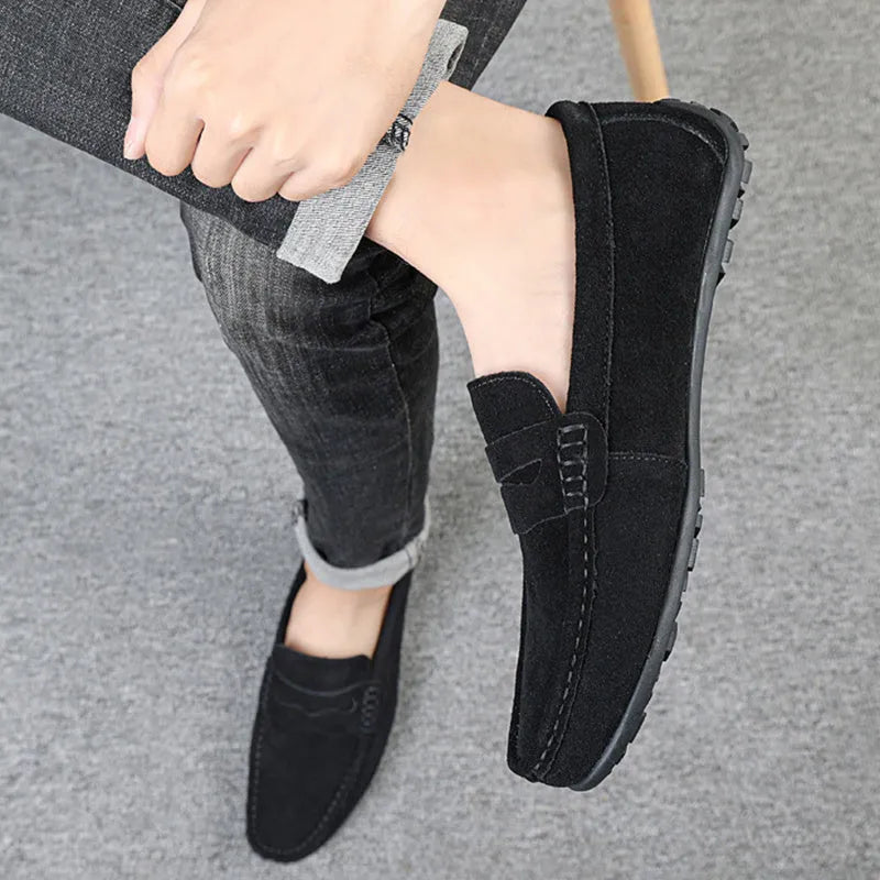Men's solid colour suede leather slip-on loafers with round toe and flat rubber sole.