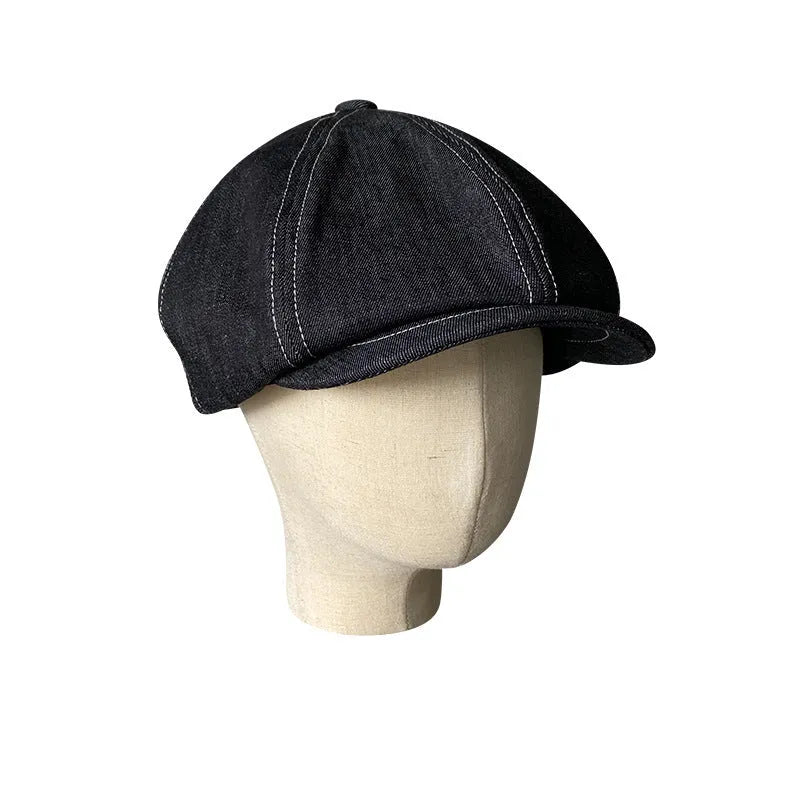 Black cotton retro-style beret for men and women on a plain background.