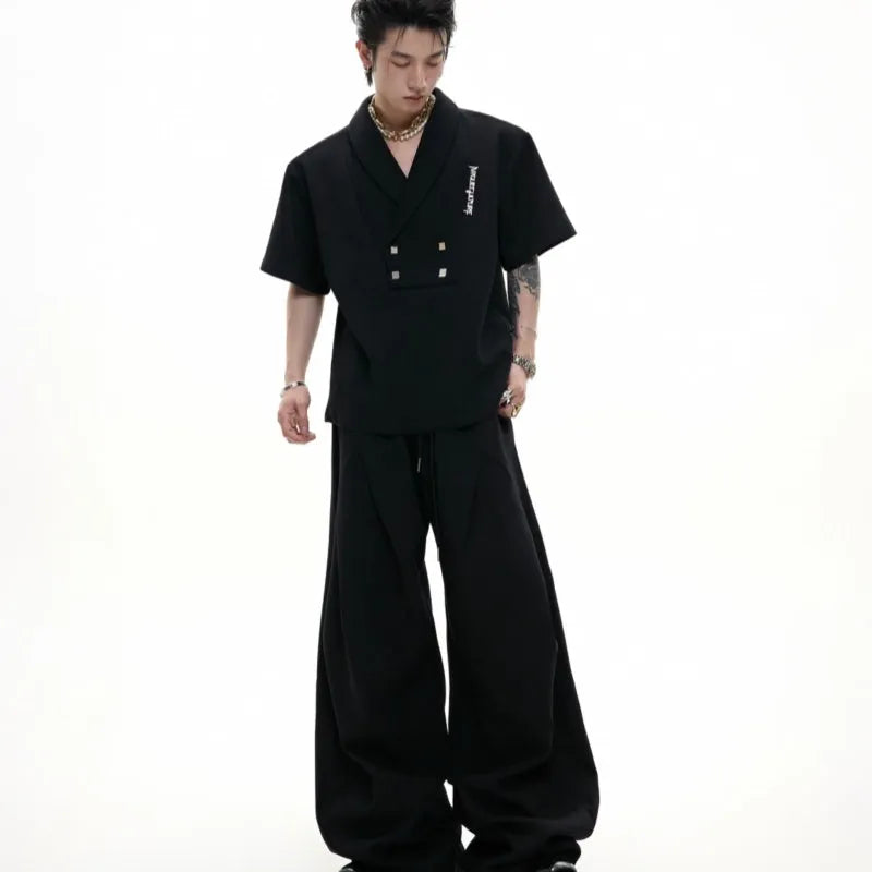 Men's dark grey cotton sports suit with V-neck short sleeve jacket and matching bottoms showing padded shoulder detail