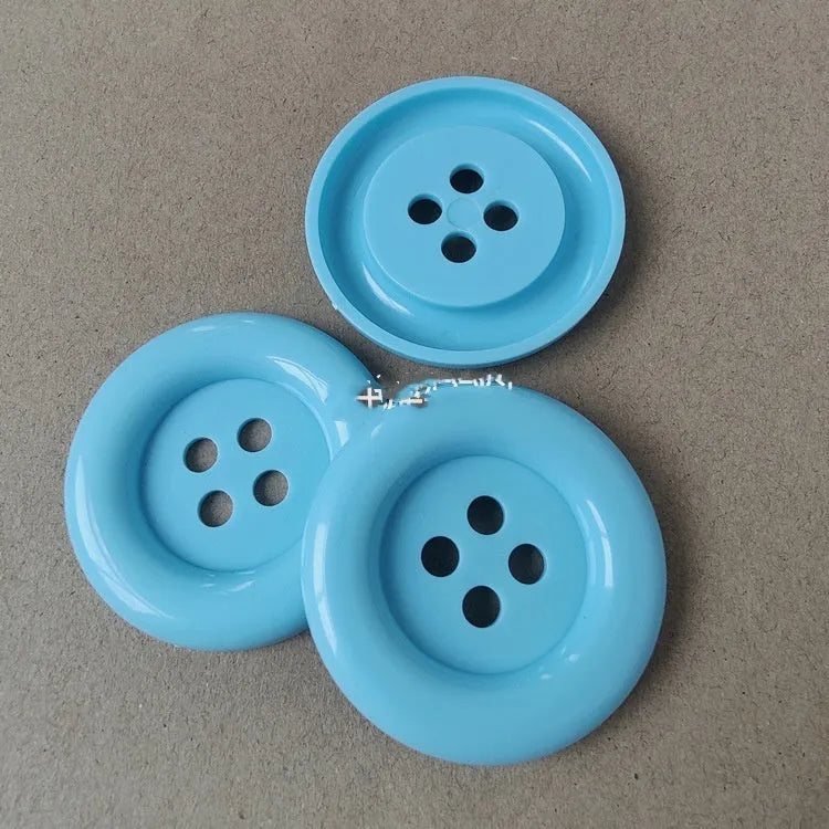 Plastic nylon oversize round sewing buttons in multiple colours showing four-hole design