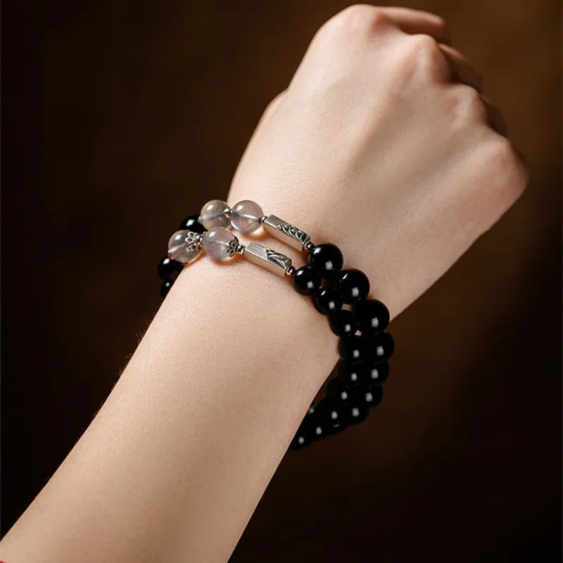Obsidian Buddha beads couple bracelet set showing 8mm women's and 10mm men's sizing differences