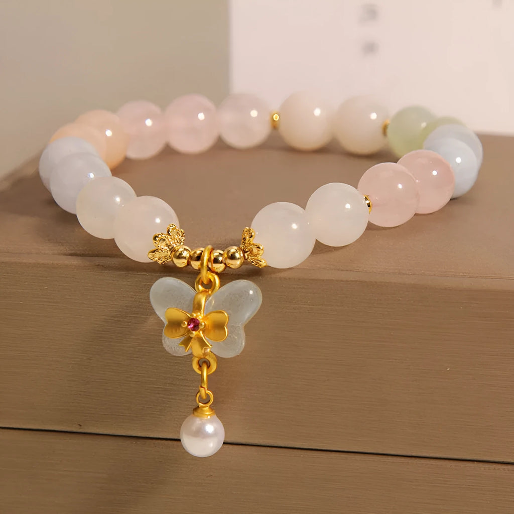 Close-up of a women's adjustable crystal bracelet with a colourful Morganite butterfly pendant.