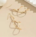 Women's gold geometric spiral earrings with ellipse diamond elements on alloy construction