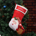 Red Christmas stocking with elk, old man and snowman printed designs in traditional American style