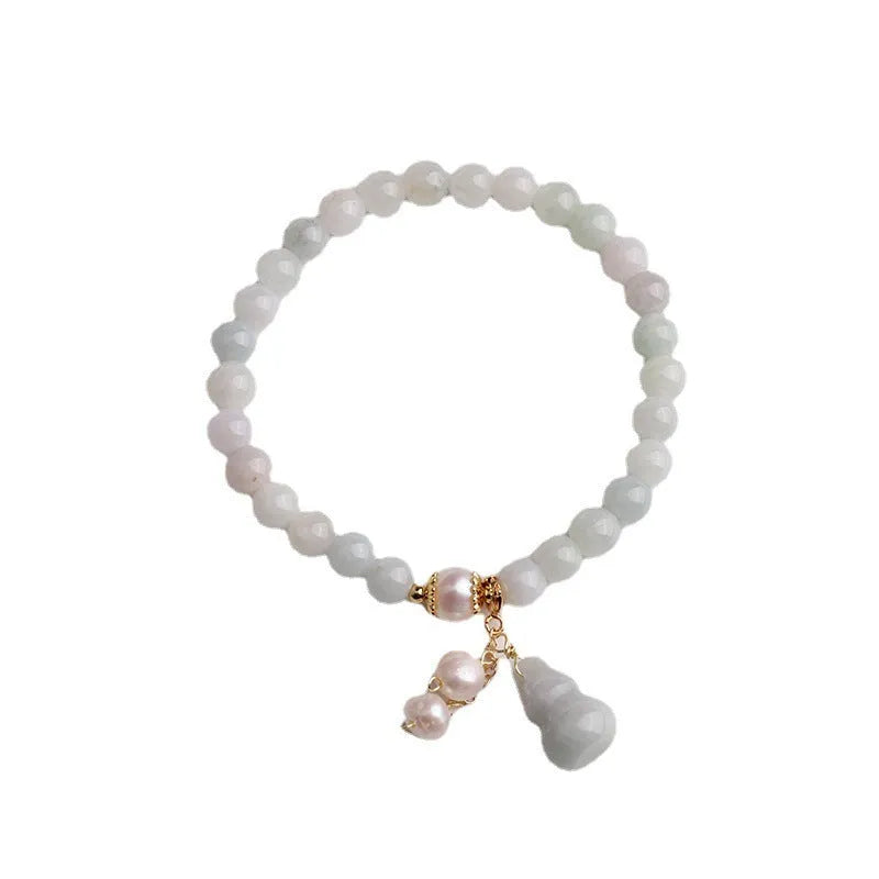 Chinese style gourd design jade bracelet for women with a pearl accent on a white background.
