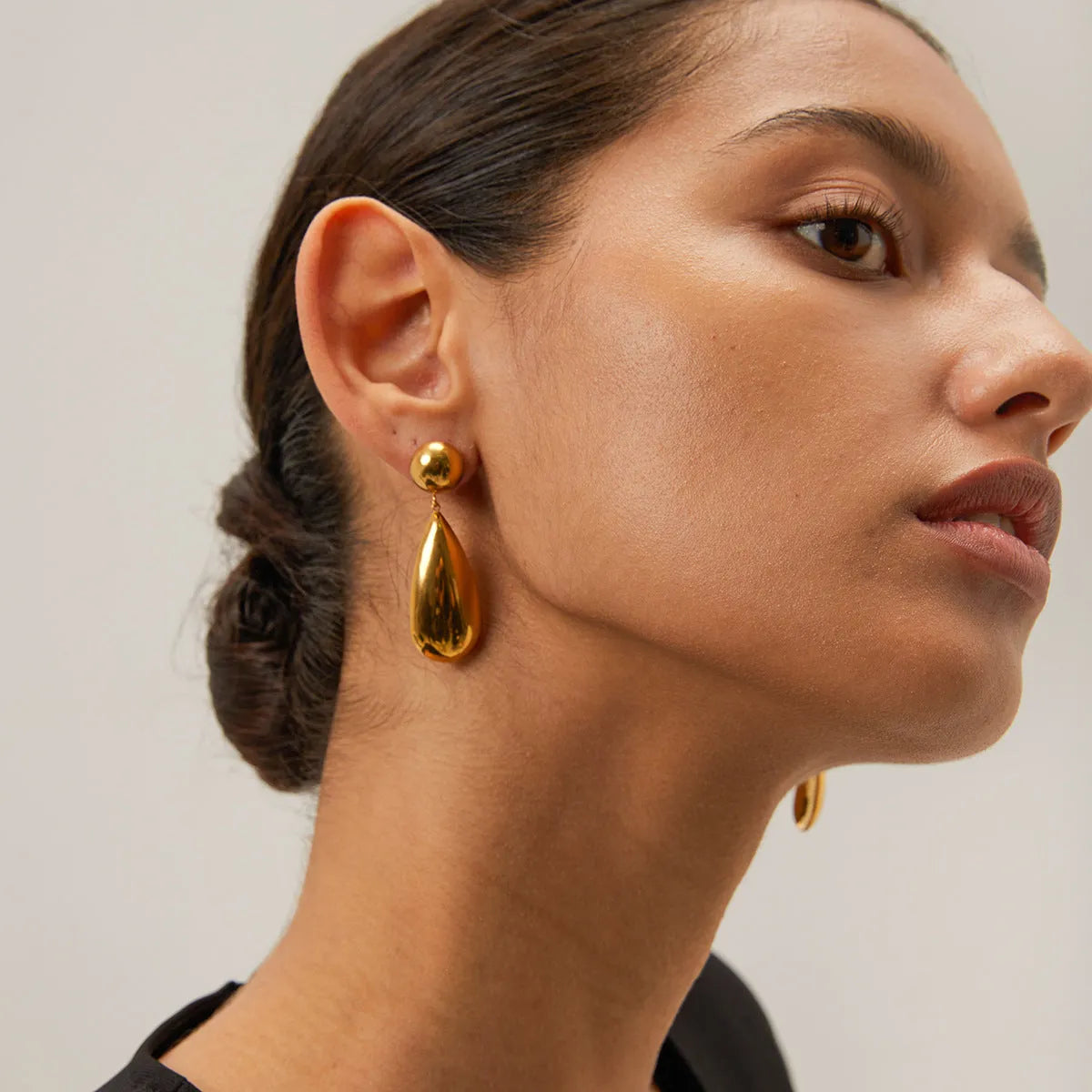 Gold stainless steel earrings with geometric hemisphere shape and water drop pendant design