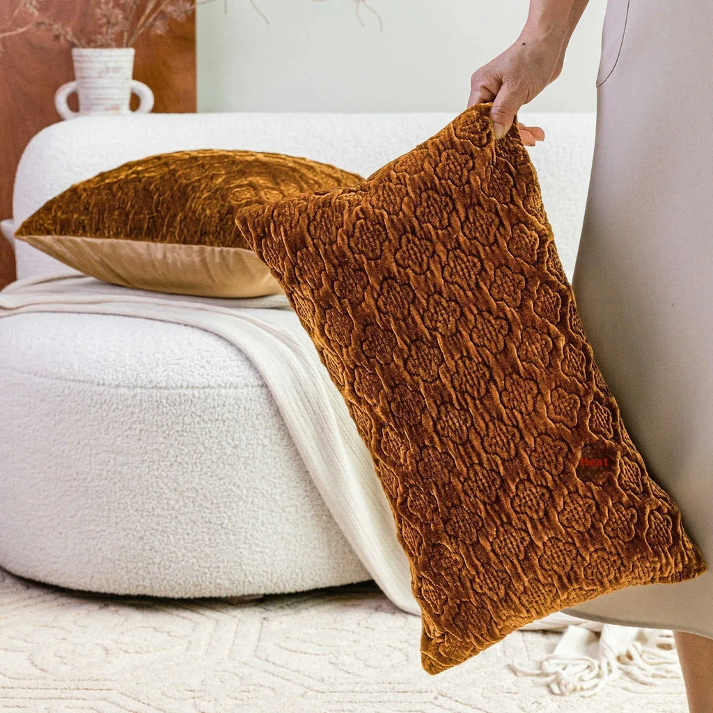 Brown gold antique-style quilted square cushion pillow on a grey sofa.
