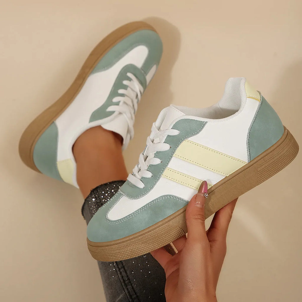 Green women's retro sports pumps with cross straps, a round toe, and a flat rubber sole.