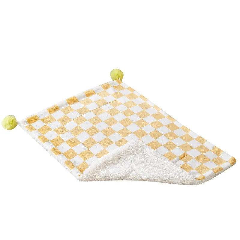 Plush pet blanket with bright plaid pattern and fur ball decorations for cats and dogs