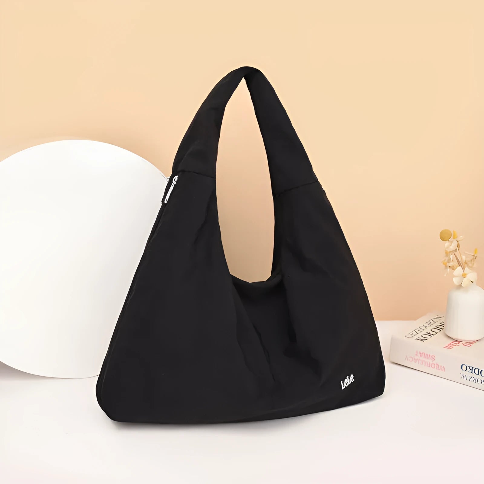 Women's heart-shaped nylon underarm bag in black, shown worn crossbody