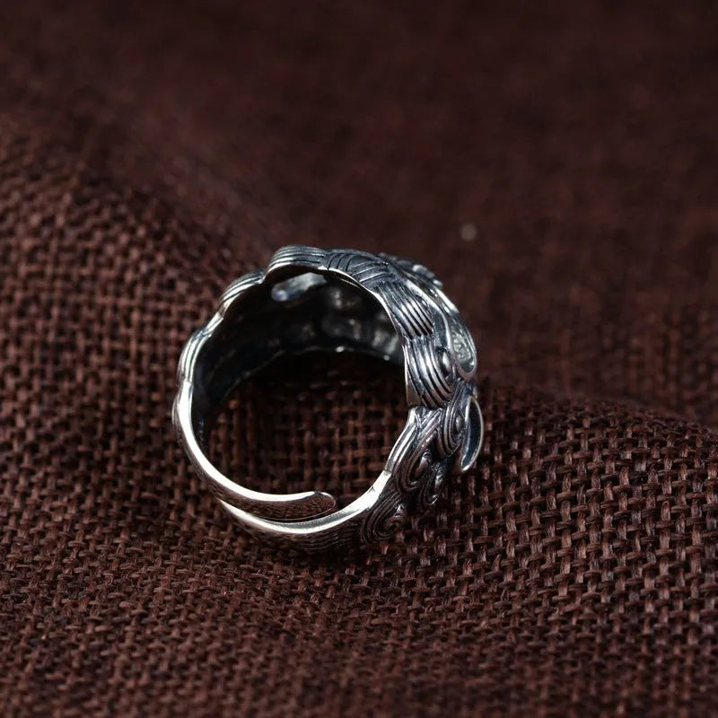 Detailed silver open ring featuring an animal zodiac beast pattern on a model's finger.