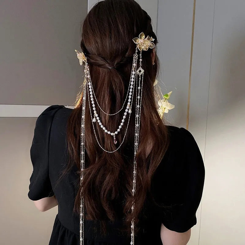 Gold coloured women's hairpin with a pearl, diamond flower and long decorative tassels.