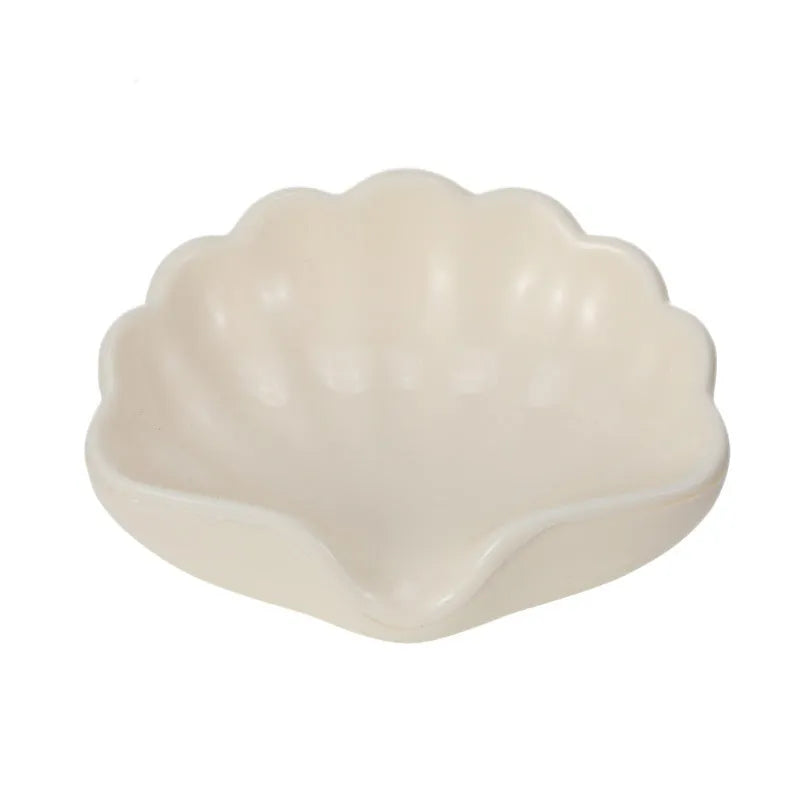 White and pink shell-shaped plastic soap dish on a bathroom countertop
