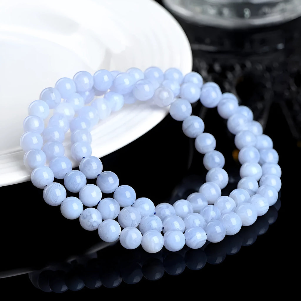 Blue multi-circle patterned agate bracelet with scattered 6-6.8mm beads and Ruyi design detail on a white background.