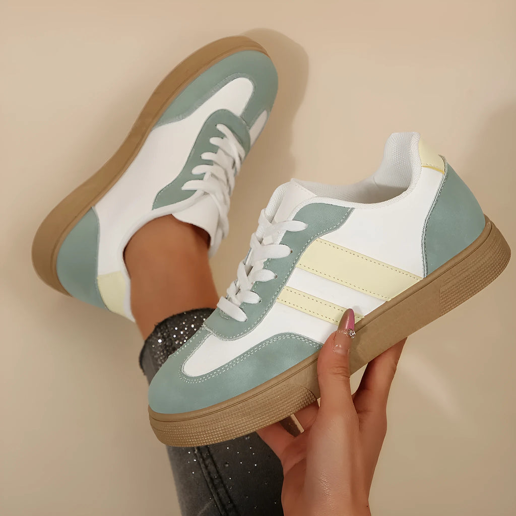 Green women's retro sports pumps with cross straps, a round toe, and a flat rubber sole.