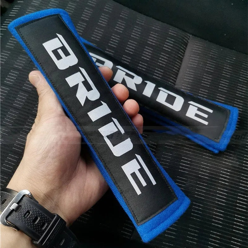 Car seat belt shoulder pads in black, blue, and red colours showing cotton sponge cloth with embroidery weaving