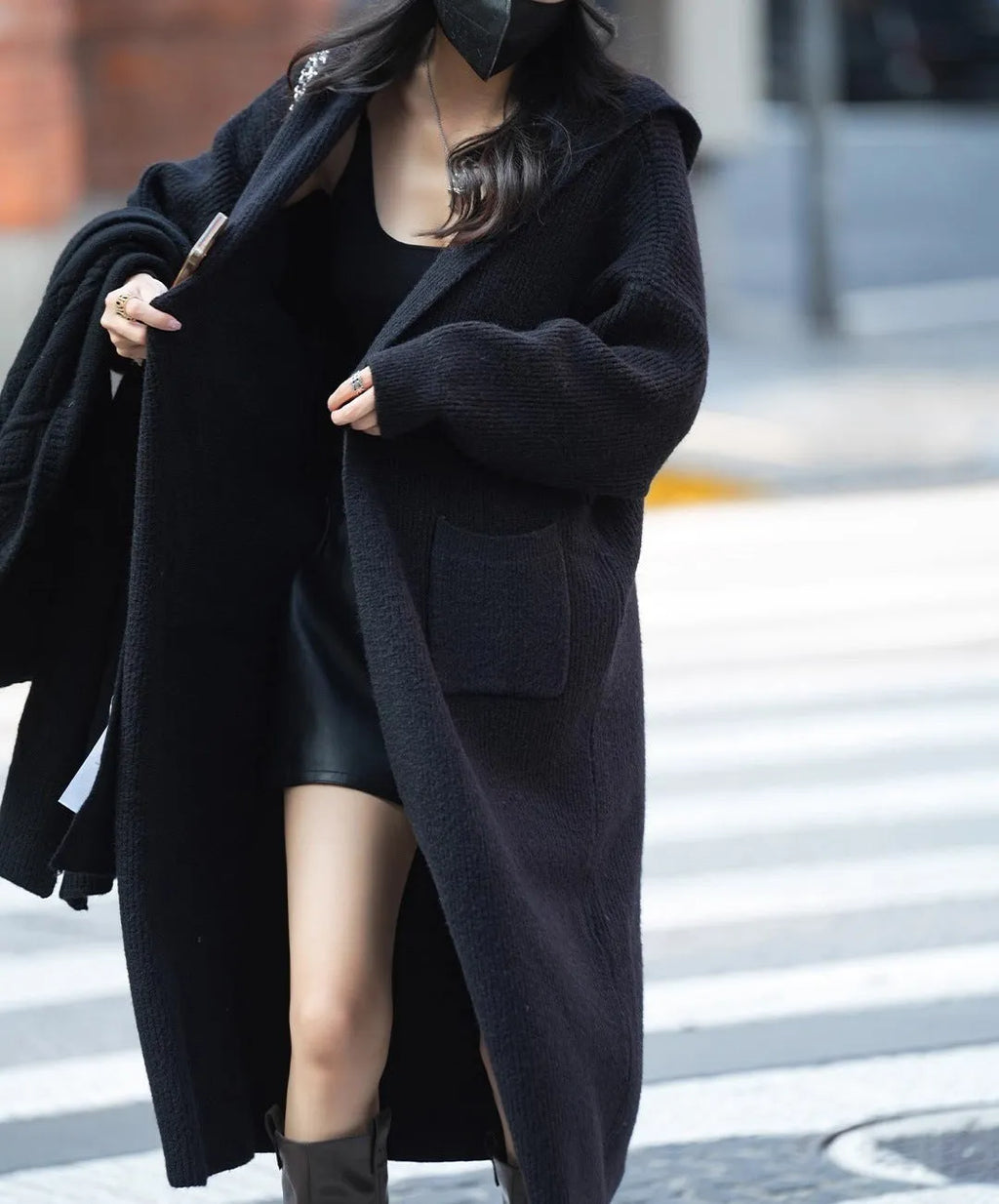 Long grey knitted hooded cardigan coat with a loose fit, shown worn open.