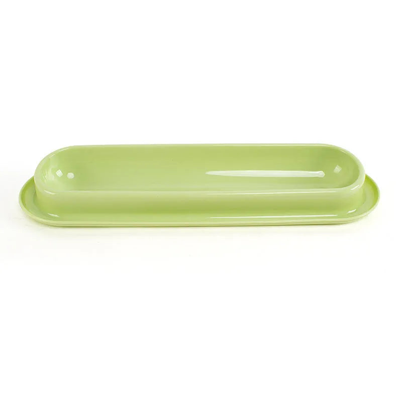 Green double-bowl pet feeder for dog food and water on a floor.