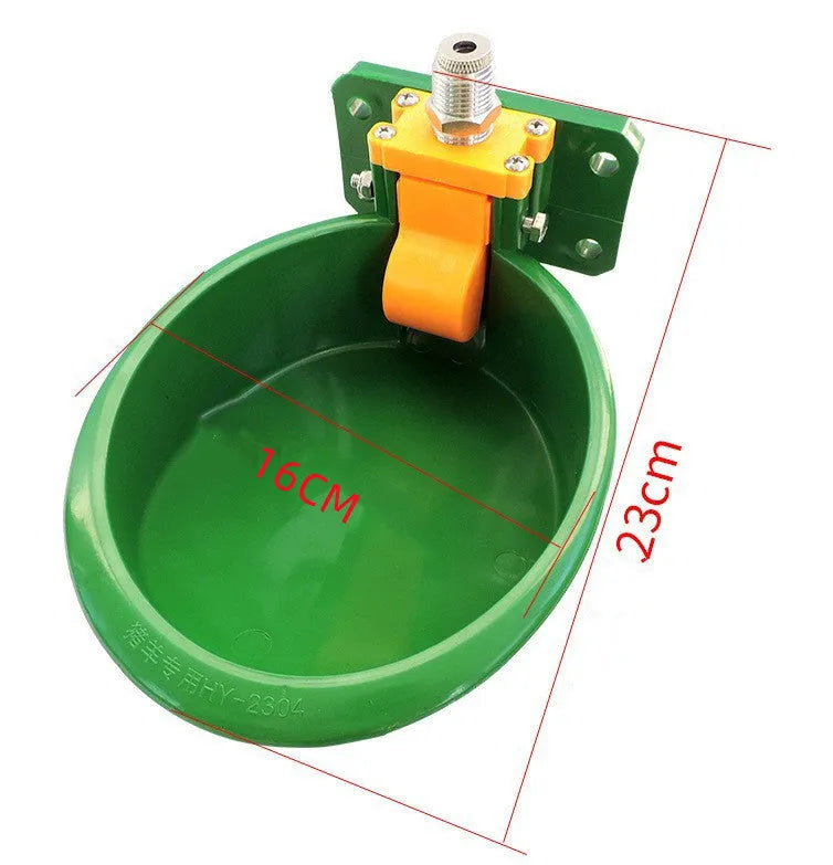 Green engineering plastic auto-drink water bowl for pigs and sheep on a farm.